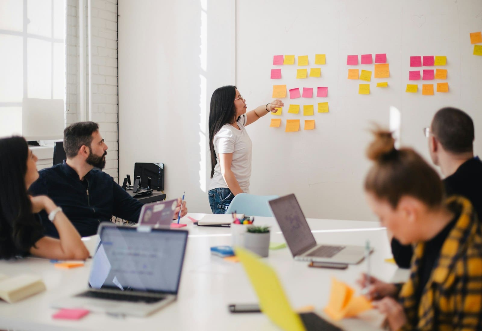 A strategist mapping customer questions across a wall of notes during a planning session