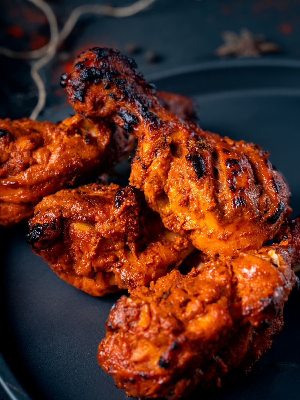 Tandoori chicken served on a dark plate